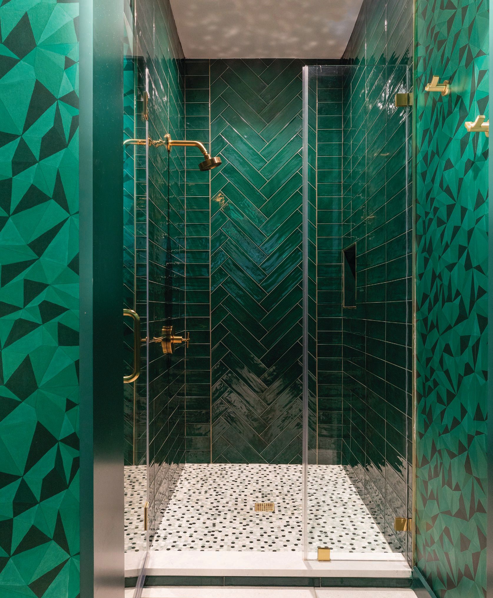The shower floor tile, made of mirrors, marble and glass, in the guest bathroom “reflects the dark green walls so some of the tiles look the exact same color as the walls,” O’Brien notes. PHOTOGRAPHED BY JULIE SOEFER