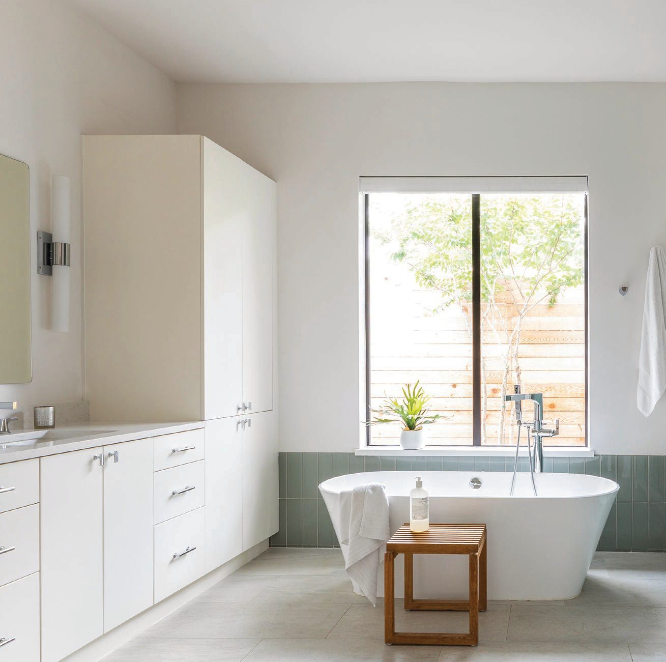 The primary bathroom features a refreshing stand-alone soaking tub and plenty of storage space. PHOTOGRAPHED BY JULIE SOEFER